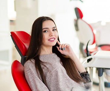 Patient smiling while sitting in the dentist’s chair