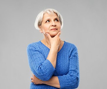 Woman making a questioning pose on a gray background