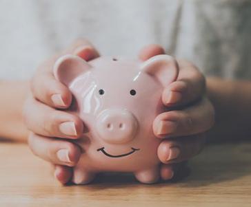 Close up of patient holding a piggy bank