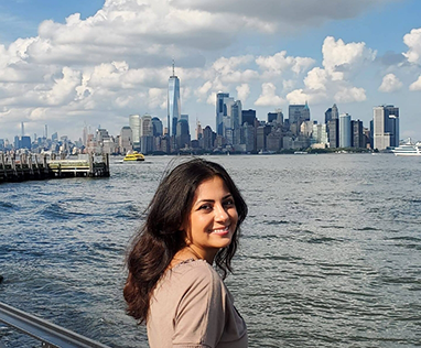 Dr. Habibi smiling in front of view of city over water