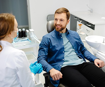 Smiling patient talking to dentist during exam
