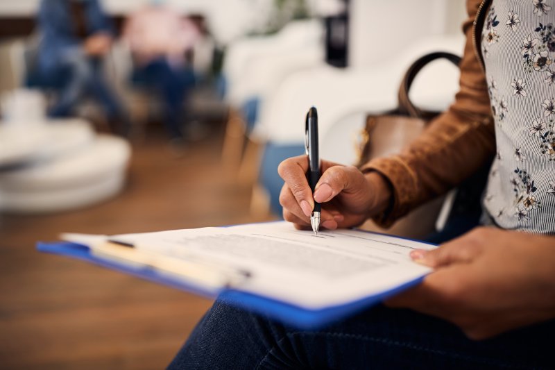 A woman filling out a dental insurance form